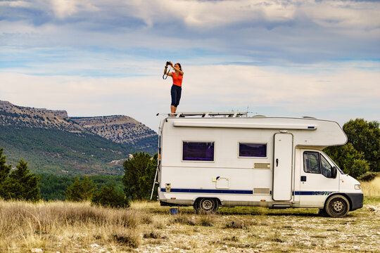 Woman traveling with caravan, taking photo from rv roof