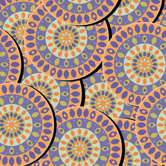 Abstract colorful patterned circles with a symmetrical ornament for printing on textiles create a trendy seamless pattern. 