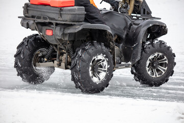 Quad bike rides on white snow in winter. Sport