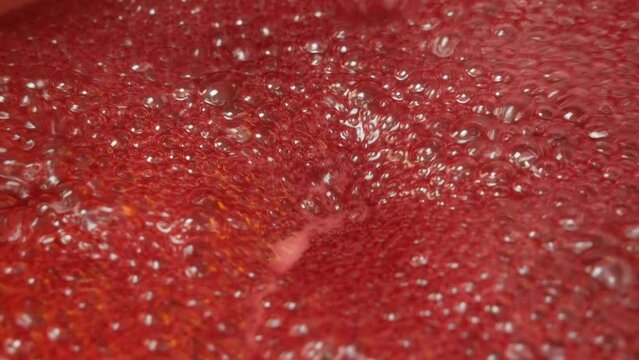 Boiling strawberry jam with foam, close-up