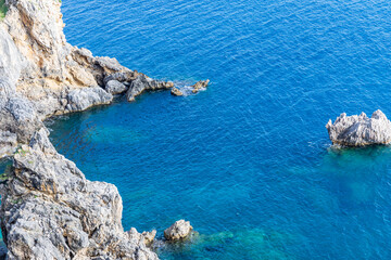 Fototapeta premium A beautiful landscape of the coast of the island of Corfu in the Ionian Sea of the Mediterranean in Greece. Pure blue clear water washes over the shores of the Greek island.