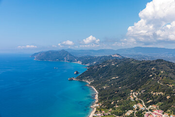 Obraz premium A beautiful landscape of the coast of the island of Corfu in the Ionian Sea of the Mediterranean in Greece. Pure blue clear water washes over the shores of the Greek island.