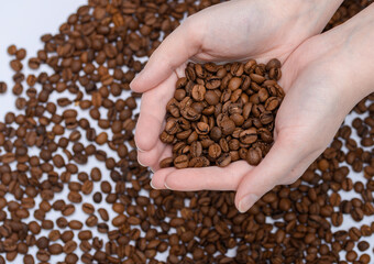 Kawa w dłoniach ma tle ziaren