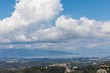 A beautiful landscape of the coast of the island of Corfu in the Ionian Sea of the Mediterranean in Greece. Pure blue clear water washes over the shores of the Greek island.