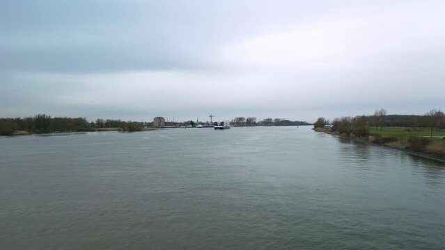 Aerial view of the big transport canal in Zwijndrecht with moving vessels in the distance on a cloudy day.