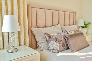 Classic bedroom interior in light ivory colors, in warm sunlight
