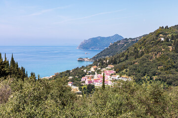 A beautiful landscape of the coast of the island of Corfu in the Ionian Sea of the Mediterranean in Greece. Pure blue clear water washes over the shores of the Greek island.