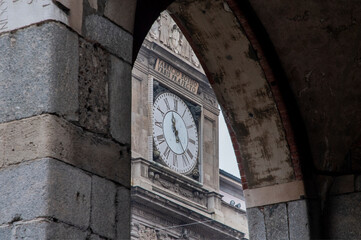 Milano, Italia. Antico orologio si vede attraverso arco dei portici. Architettura della città.
