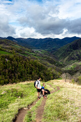 Fototapeta na wymiar Young couple hiking in the mountains of the French Basque Country with their dog