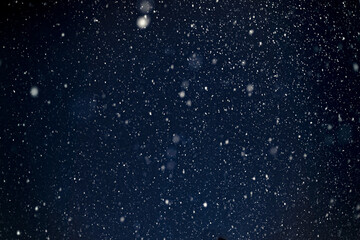 Fototapeta premium blizzard natural blurred background, flying snow shot against the night sky