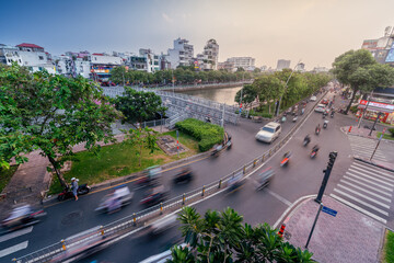 Busy traffic during sunset and night, colorful perspective of Ho Chi Minh city with numerous hotel, bar and shop sign boards, crowded with people, motorbikes