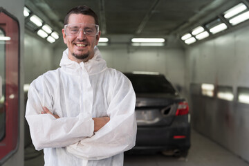 Automotive paint services and quality auto body shop concept. Male car mechanic working and...