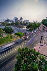 Busy traffic during sunset and night, colorful perspective of Ho Chi Minh city with numerous hotel, bar and shop sign boards, crowded with people, motorbikes