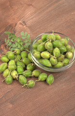 Fresh Green chickpeas on a branch, and in the pod, isolated on wooden background.