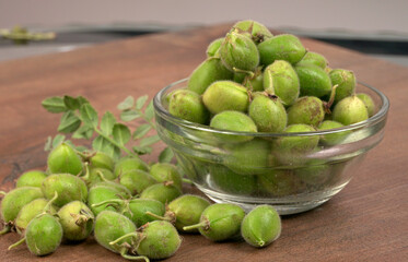 Fresh Green chickpeas on a branch, and in the pod, isolated on wooden background.