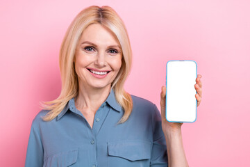 Naklejka premium Photo of funny cute lady dressed grey blouse showing modern gadget touch screen emtpy space isolated pink color background