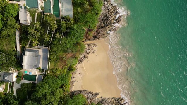 Phuket, Thailand: Top down drone footage of the Nai Thon and Banana beaches in the Phuket tropical island lined with luxury real estate and resort in the Andaman sea in Thailand. 