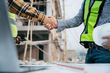 Construction workers, architects and engineers shake hands while working for teamwork and cooperation after completing an agreement in an office facility, successful cooperation concept.