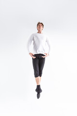 Caucasian Handsome Young Man Dancing Ballet Posing in Flying Ballet Pose with Lifted Hands in White Shirt On White.