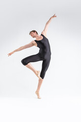 Fototapeta na wymiar Modern Ballet Dancing. Contemporary Art Ballet of Young Caucasian Athletic Man in Black Suit Dancing