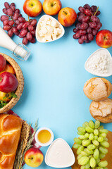 Jewish Shavuot Holiday Card. Dairy Products, Apples, Cheese, Grapes, Bread, Milk on Blue Background.