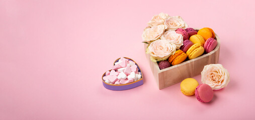 Cookies Macaroons in Gift Box, Rose Flowers and Candies on Pink Background. Holiday Presents Concept
