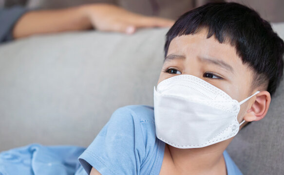 Angry Asian kids with medical face mask crying because he don't want to wear medical mask.
