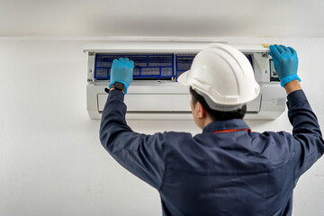 Air conditioner maintenance technician checks the cleanliness of the air conditioner inside the house.