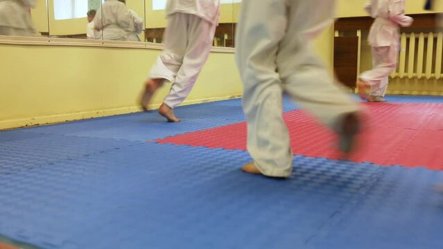 Children are warming up their legs before demonstration of karate. Healthy lifestyle concept, playing sports. Martial arts. Judo, Jiu Jitsu. Bold, strong. does a warm-up, workouts