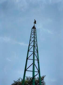 Speaker antenna or green telephone tower on sky and clouds background