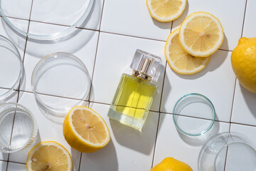 Glass transparent bottle of perfume extracted from Lemon essential oil arranged with petri dishes...