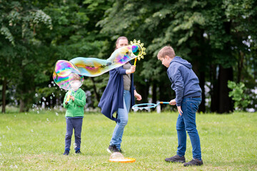 Fototapeta premium Mom and son are playing in the park. Cheerful happy family having a picnic. Vacations and trips out of town in country.