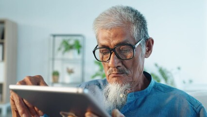 Asian senior elder man hair grey using laptop at home morning sunlight, Close-up face of grandfather