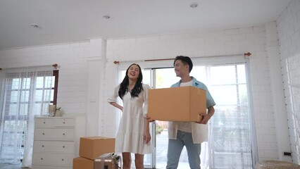 Happy Asian couple moving into their new home. - Powered by Adobe