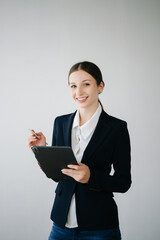 Smiling caucasian young businesswoman bank employee worker manager boss ceo looking at camera, using tablet, laptop and notepad online isolated in white background.