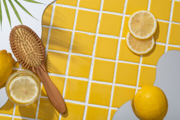 A wooden brush displayed with geometric mirrors and Lemon slices. Lemon (Citrus limon) is high in...