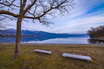 湖の岸辺の公園の石造りのベンチ。
