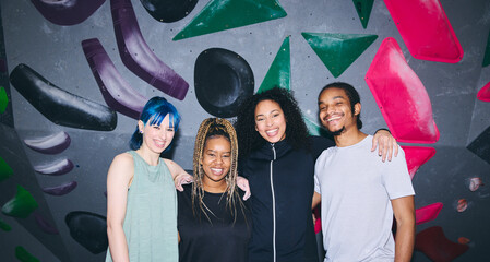 Retro Style Portrait Of Group Of Multi-Cultural Friends By Climbing Wall At Indoor Activity Centre