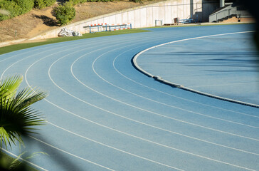 Pista de atletismo con curva carriles de distancia para practicar deporte en color azul.