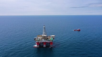 day. aerial survey, there is a semi-submersible drilling platform with the name "Polar Star" in red and white color in the sea, next to a red-colored vessel.