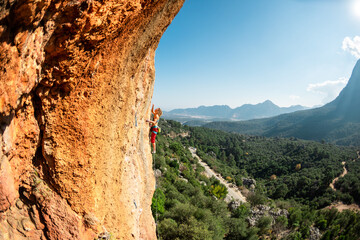 Fototapeta na wymiar Girl climbs on the rock, rock climbing in Turkey, the sports girl is engaged in rock climbing.
