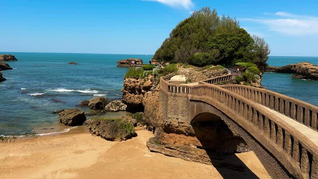 Stone bridge to the Rocher du Basta, the scenic rock and major landmark in the coast of Biarritz, France. High quality 4k footage