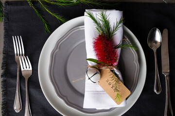 Australian Christmas table place setting with a bottlebrush flower and tag reading "noel"
