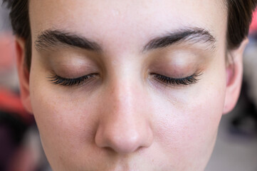 Close-up of a caucasian woman after eyelash lamination procedure. 