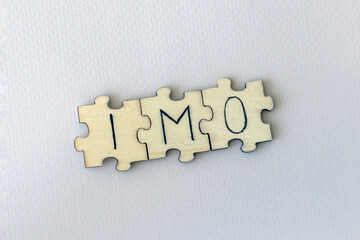 Obraz premium The acronym IMO, which stands for In My Opinion. The letters written on the puzzles.