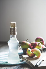Bottle of apple cider vinegar on rustic background