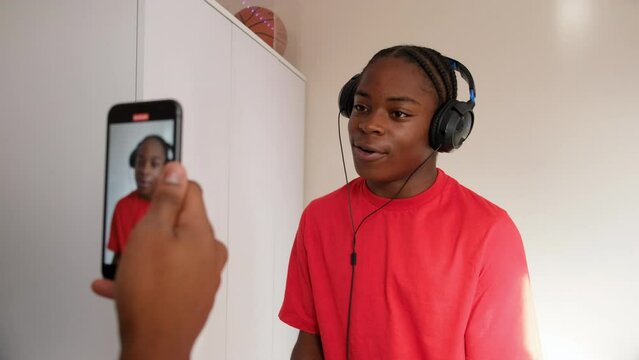 Teenager recording rapping friend at home