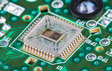 Closeup of microchip die inside optical sensor on green printed circuit board. Electronic square...