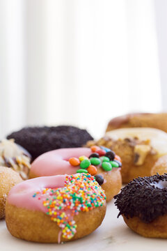Vertical shot of pink, and black topped donuts
