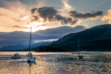 Sailing boats at sunset at Loch Leven near Glencoe in the Highlands of Scotland, UK